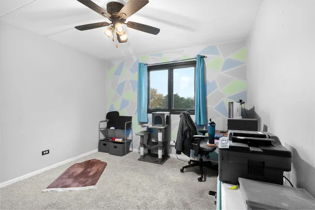 a view of a livingroom with workspace and a window