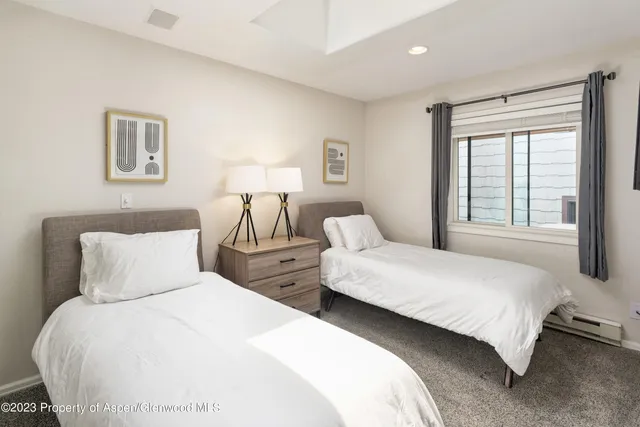 a bedroom with two beds and a window