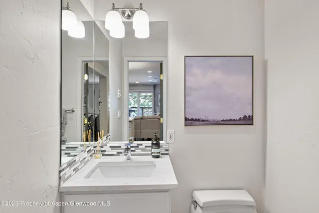 a bathroom with a sink a toilet and a mirror