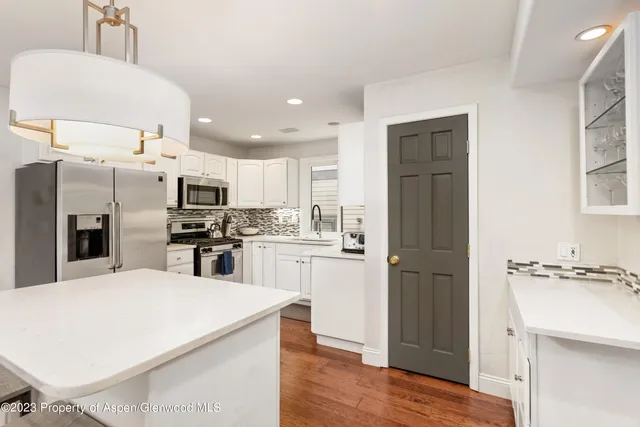 a kitchen with stainless steel appliances a refrigerator sink and microwave