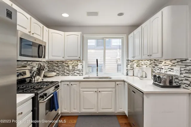 a kitchen with stainless steel appliances a sink a stove and cabinets