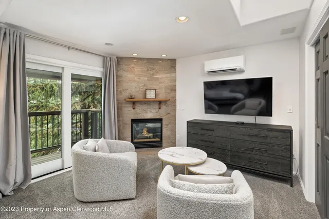 a living room with furniture a fireplace and a flat screen tv