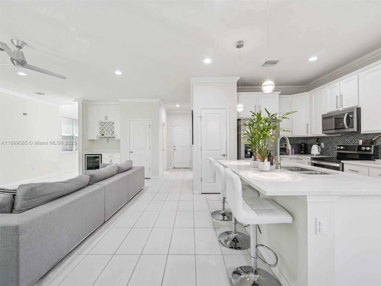 4325 Large Leaf Lane Hollywood, FL 33021 - Photo 14 of 72 a large white kitchen with a large window a sink and stainless steel appliances