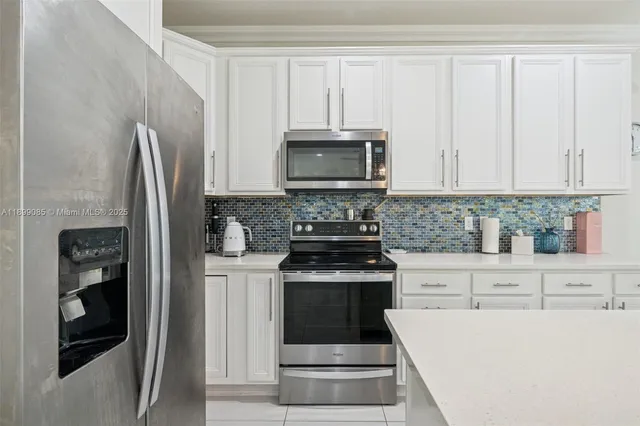 a view of a kitchen with a sink and a refrigerator
