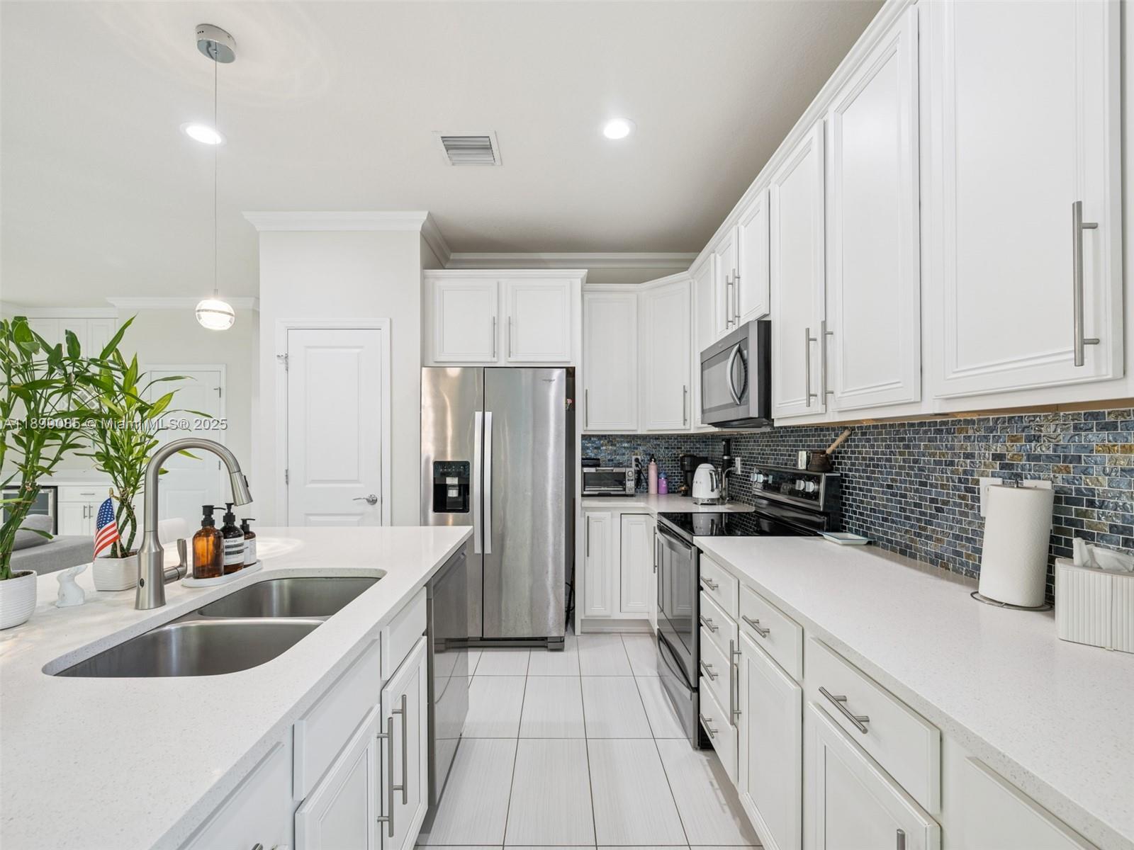 4325 Large Leaf Lane Hollywood, FL 33021 - Photo 19 of 72 a kitchen with a sink a refrigerator and cabinets