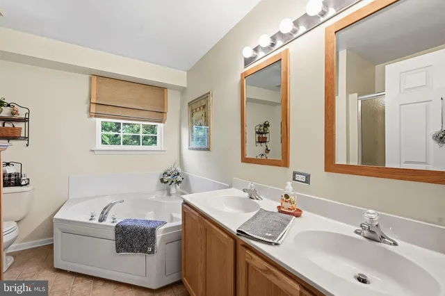 a bathroom with a tub a sink and mirror