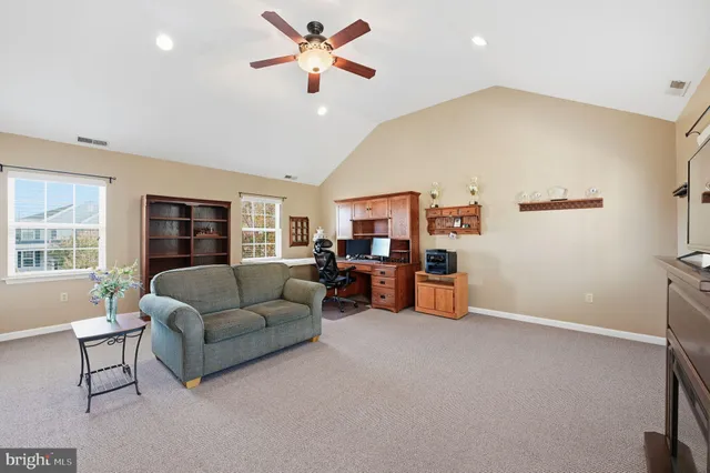 a living room with furniture and a ceiling fan