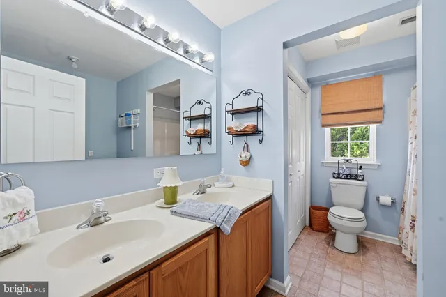 a bathroom with a sink vanity granite and toilet