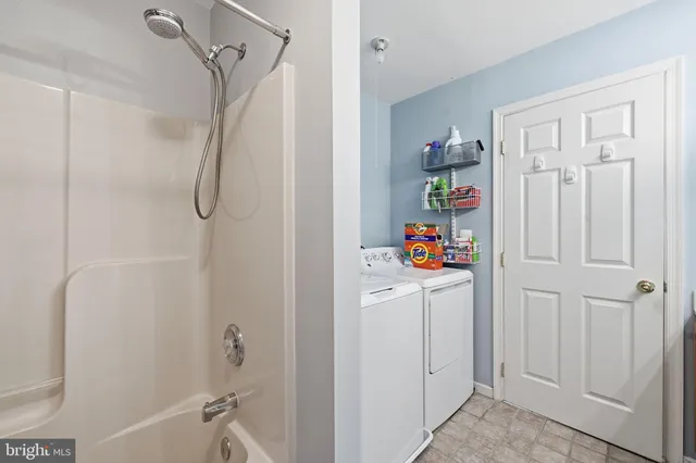 a white bath tub sitting next to a white wall