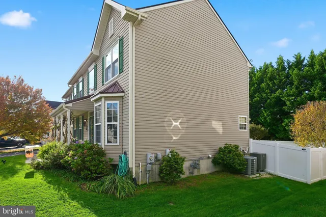 a view of a house with brick walls and a yard with plants