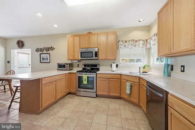 a kitchen with a sink window and white stainless steel appliances