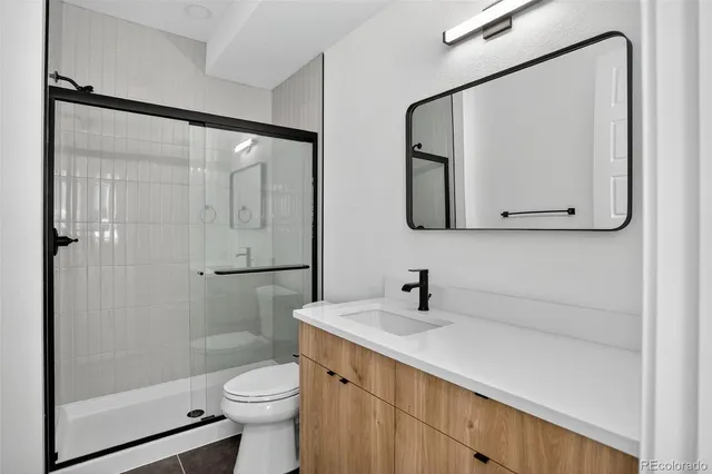 an empty room with wooden floor closet and windows