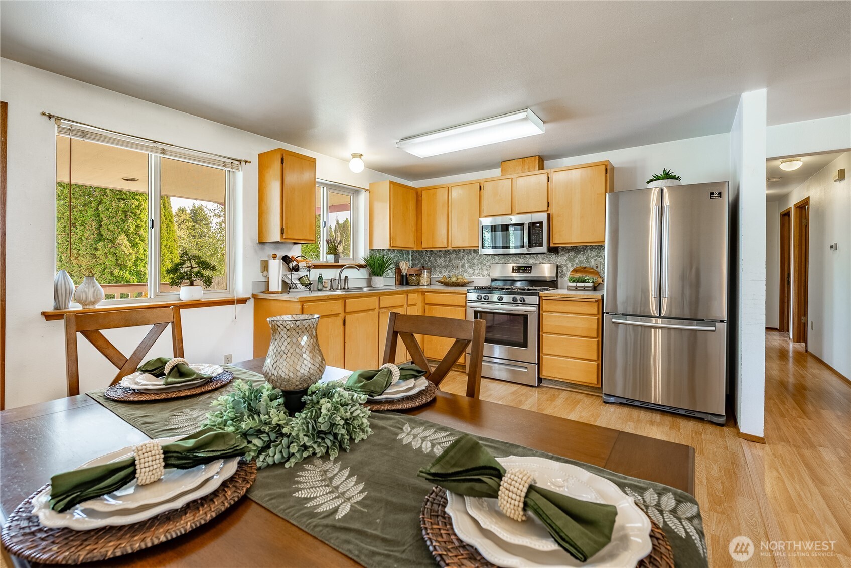 2136 Hawthorne Street Ferndale, WA 98248 - Photo 16 of 26 a kitchen with stainless steel appliances wooden floor dining table and chairs