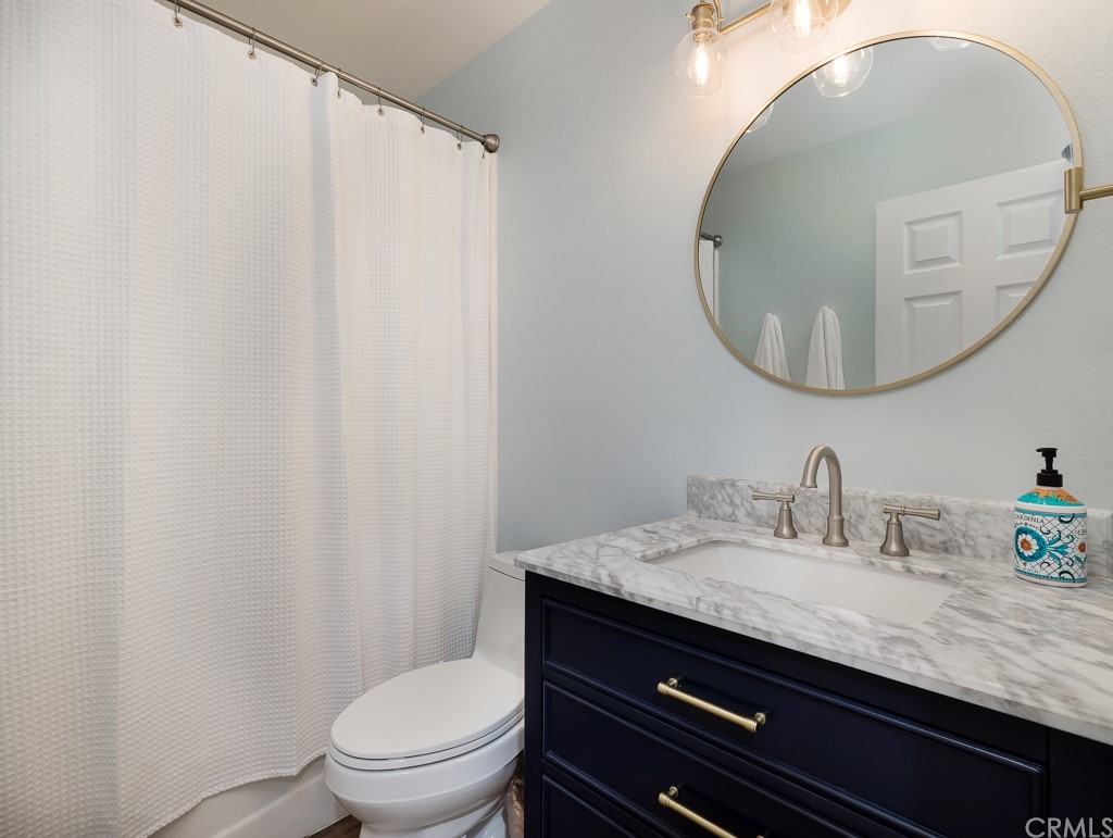 408 Richmond Street, Unit 10 El Segundo, CA 90245 - Photo 18 of 24 a bathroom with a granite countertop sink a toilet and a mirror
