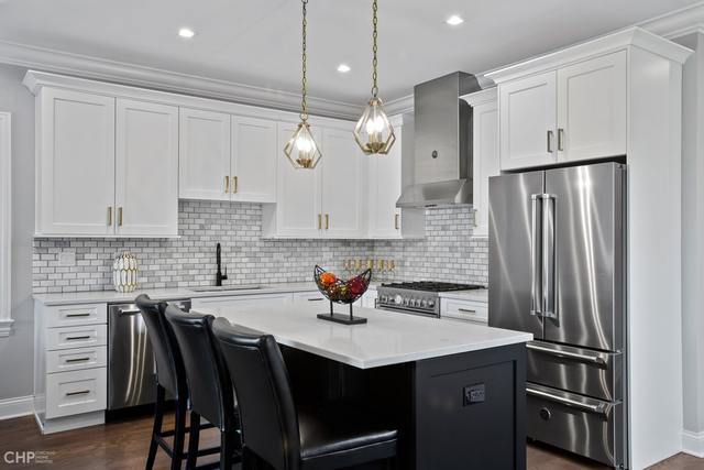 211 South Hamilton Avenue, Unit 2 Chicago, IL 60612 - Photo 6 of 22 a kitchen with stainless steel appliances granite countertop a sink a stove a refrigerator and island with wooden floor