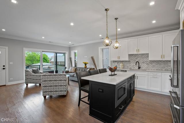 211 South Hamilton Avenue, Unit 2 Chicago, IL 60612 - Photo 9 of 22 a kitchen with a stove sink and living room view