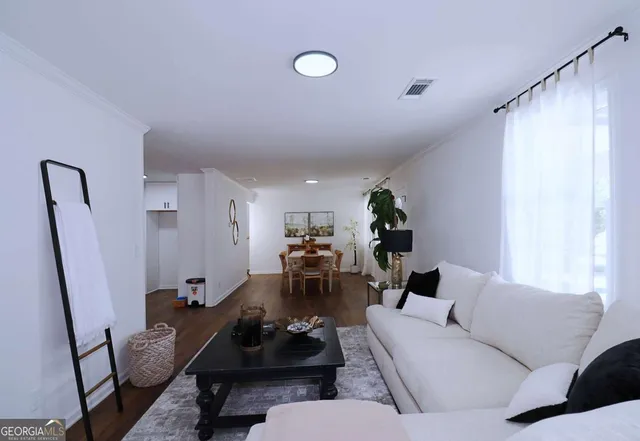 a living room with furniture and wooden floor