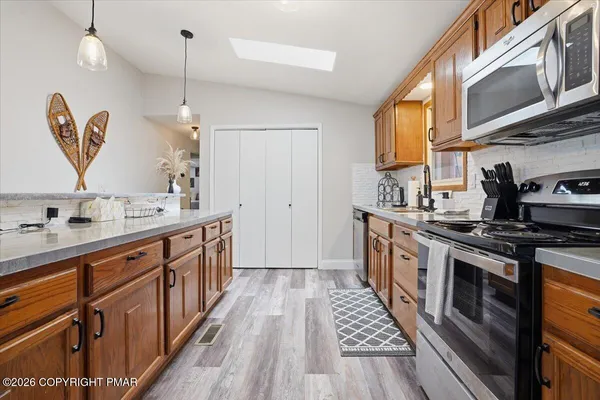 a kitchen with stainless steel appliances granite countertop a sink stove and cabinets