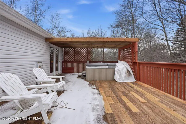 a view of a roof deck with wooden fence and a couple of chairs