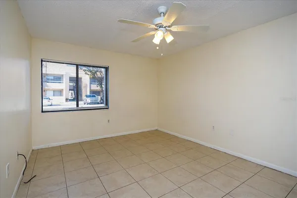 an empty room with windows and fan