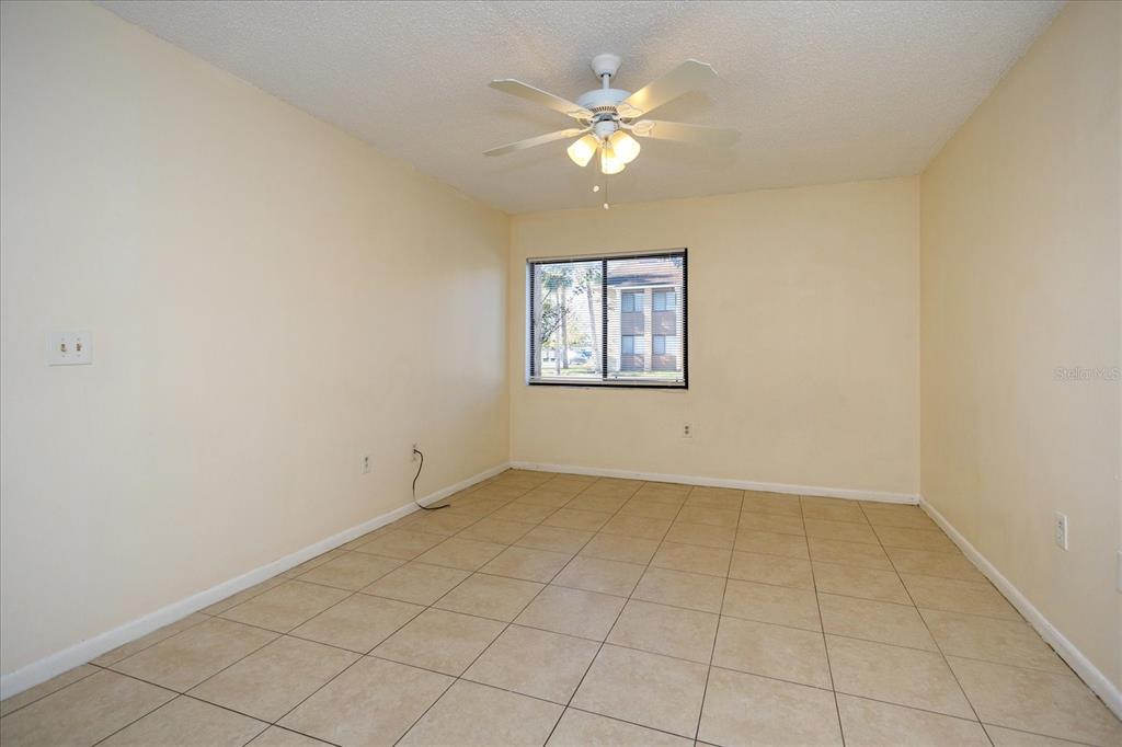 5013 Vineland Road, Unit 108 Orlando, FL 32811 - Photo 12 of 20 an empty room with windows and chandelier fan