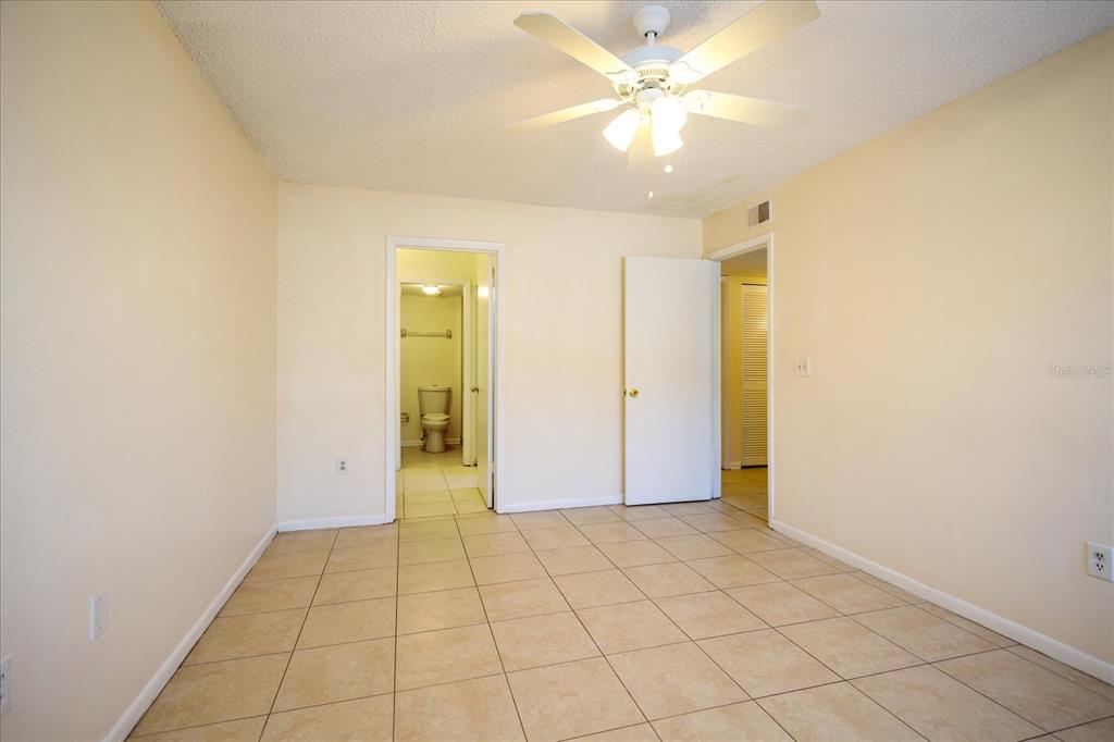 5013 Vineland Road, Unit 108 Orlando, FL 32811 - Photo 13 of 20 an empty room with a ceiling fan and carpet