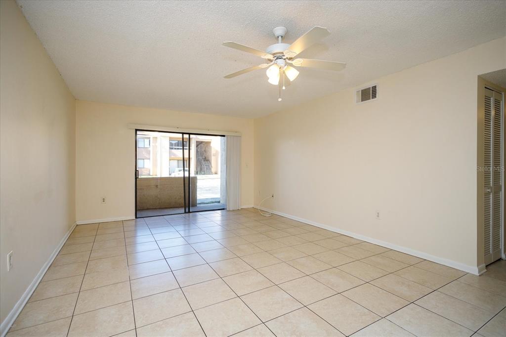 5013 Vineland Road, Unit 108 Orlando, FL 32811 - Photo 4 of 20 a view of an empty room with window and chandelier fan