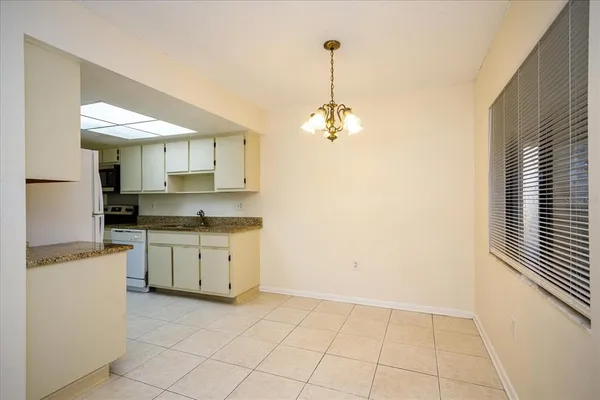a kitchen with granite countertop white cabinets and white appliances