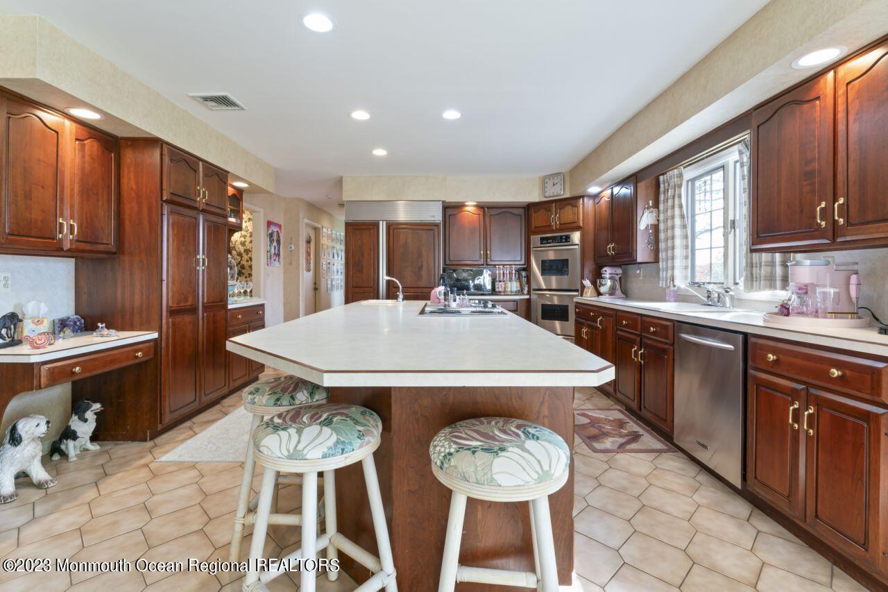 111 Muhlenbrink Road Colts Neck, NJ 07722 - Photo 22 of 73 a kitchen with stainless steel appliances a table chairs and a refrigerator