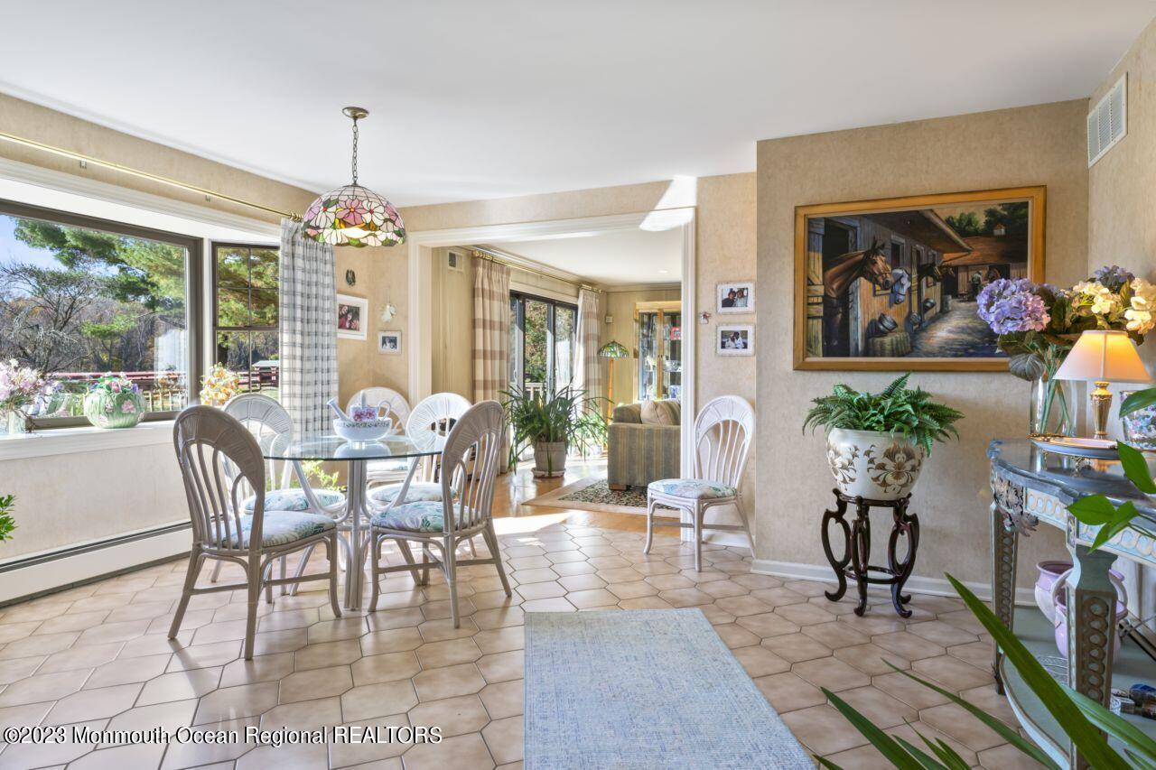 111 Muhlenbrink Road Colts Neck, NJ 07722 - Photo 26 of 73 a dining room with wooden floor a chandelier a wooden table and chairs