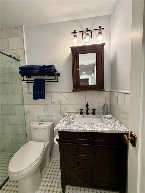 6525 Engram Road New Smyrna Beach, FL 32169 - Photo 15 of 36 a bathroom with a granite countertop toilet sink and mirror