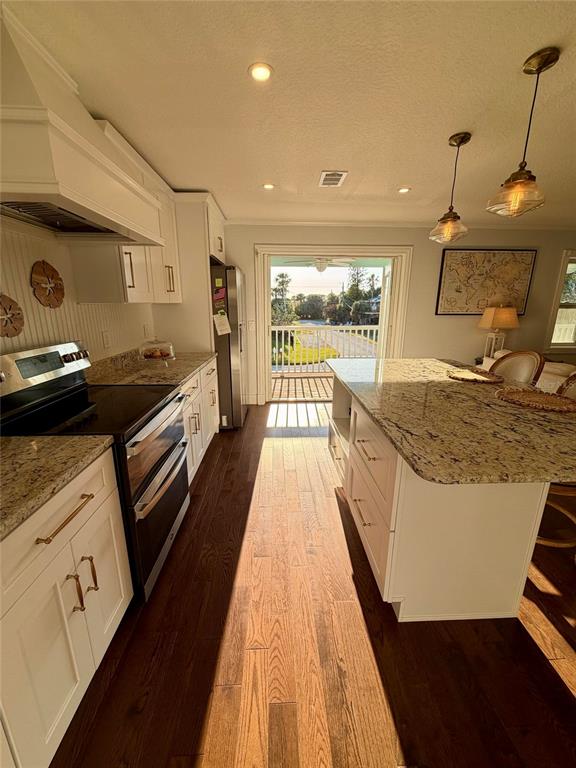 6525 Engram Road New Smyrna Beach, FL 32169 - Photo 22 of 36 a view of a kitchen with kitchen island a sink wooden floor and a counter top space