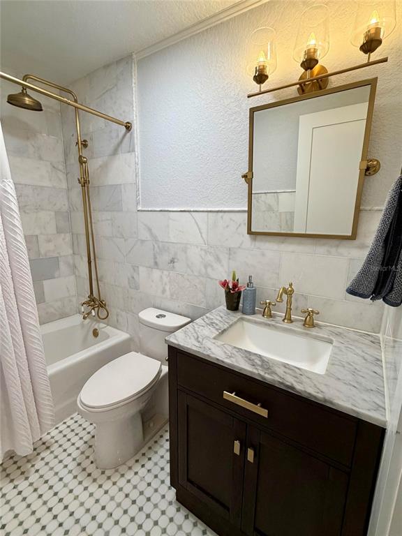 6525 Engram Road New Smyrna Beach, FL 32169 - Photo 28 of 36 a bathroom with a granite countertop sink toilet a mirror and bathtub