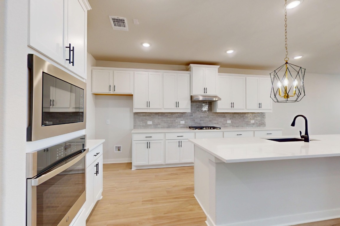 3965 Waco Way Leander, TX 78641 - Photo 12 of 38 a kitchen with a sink stainless steel appliances and cabinets