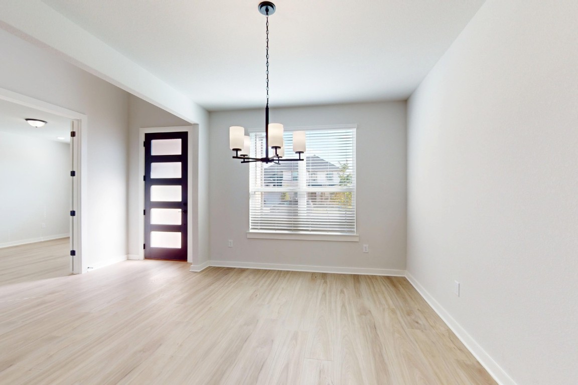 3965 Waco Way Leander, TX 78641 - Photo 13 of 38 a view of an empty room with a window and wooden floor