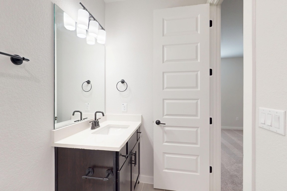 3965 Waco Way Leander, TX 78641 - Photo 27 of 38 a bathroom with a sink a mirror and shower