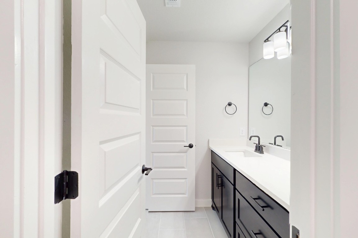 3965 Waco Way Leander, TX 78641 - Photo 29 of 38 a bathroom with a double vanity sink a mirror and a bathtub