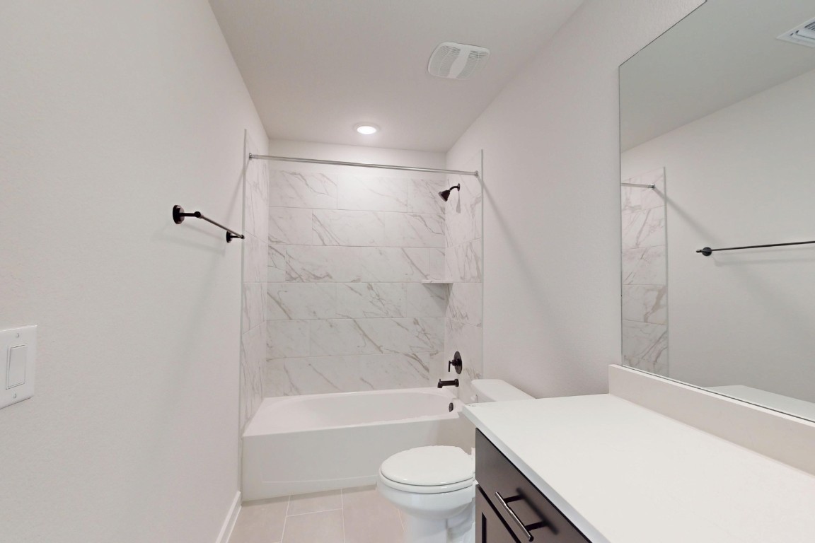 3965 Waco Way Leander, TX 78641 - Photo 32 of 38 a bathroom with a sink a toilet a mirror and a shower