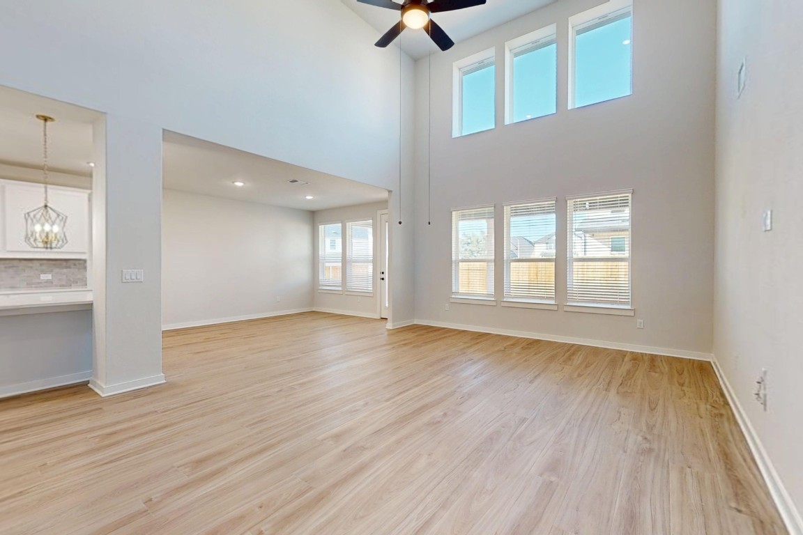 3965 Waco Way Leander, TX 78641 - Photo 4 of 38 a view of an empty room with a window and wooden floor