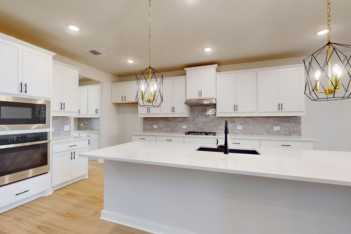3965 Waco Way Leander, TX 78641 - Photo 9 of 38 a kitchen with stainless steel appliances a sink a stove a refrigerator and cabinets