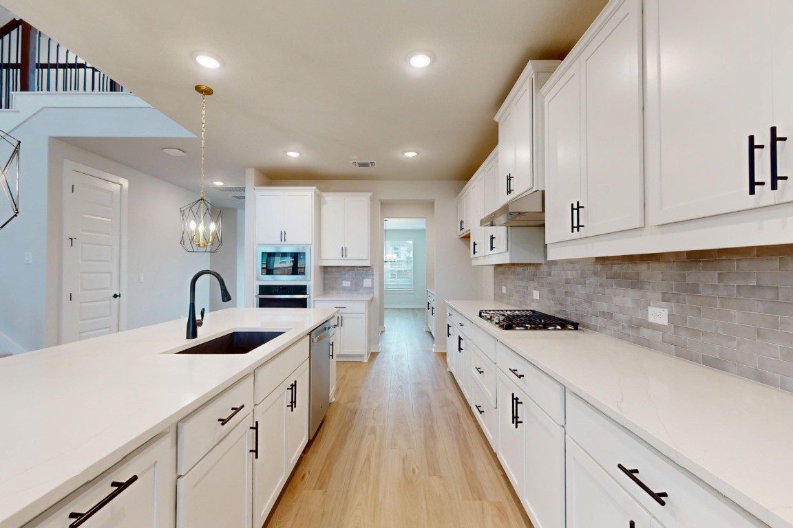 3965 Waco Way Leander, TX 78641 - Photo 10 of 38 a kitchen with white cabinets stove and sink