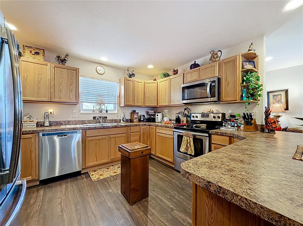 3531 Thorne Path Oxford, FL 34484 - Photo 12 of 56 a kitchen with granite countertop wooden floors appliances and sink