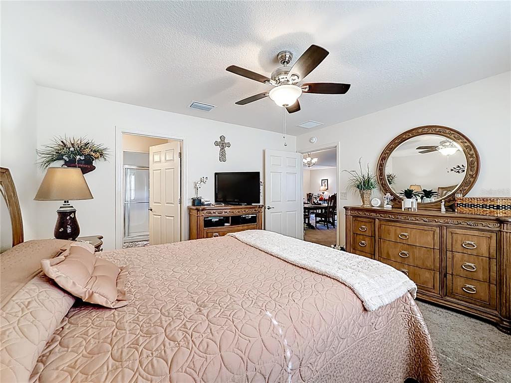 3531 Thorne Path Oxford, FL 34484 - Photo 33 of 56 a bedroom with a large bed and a chandelier