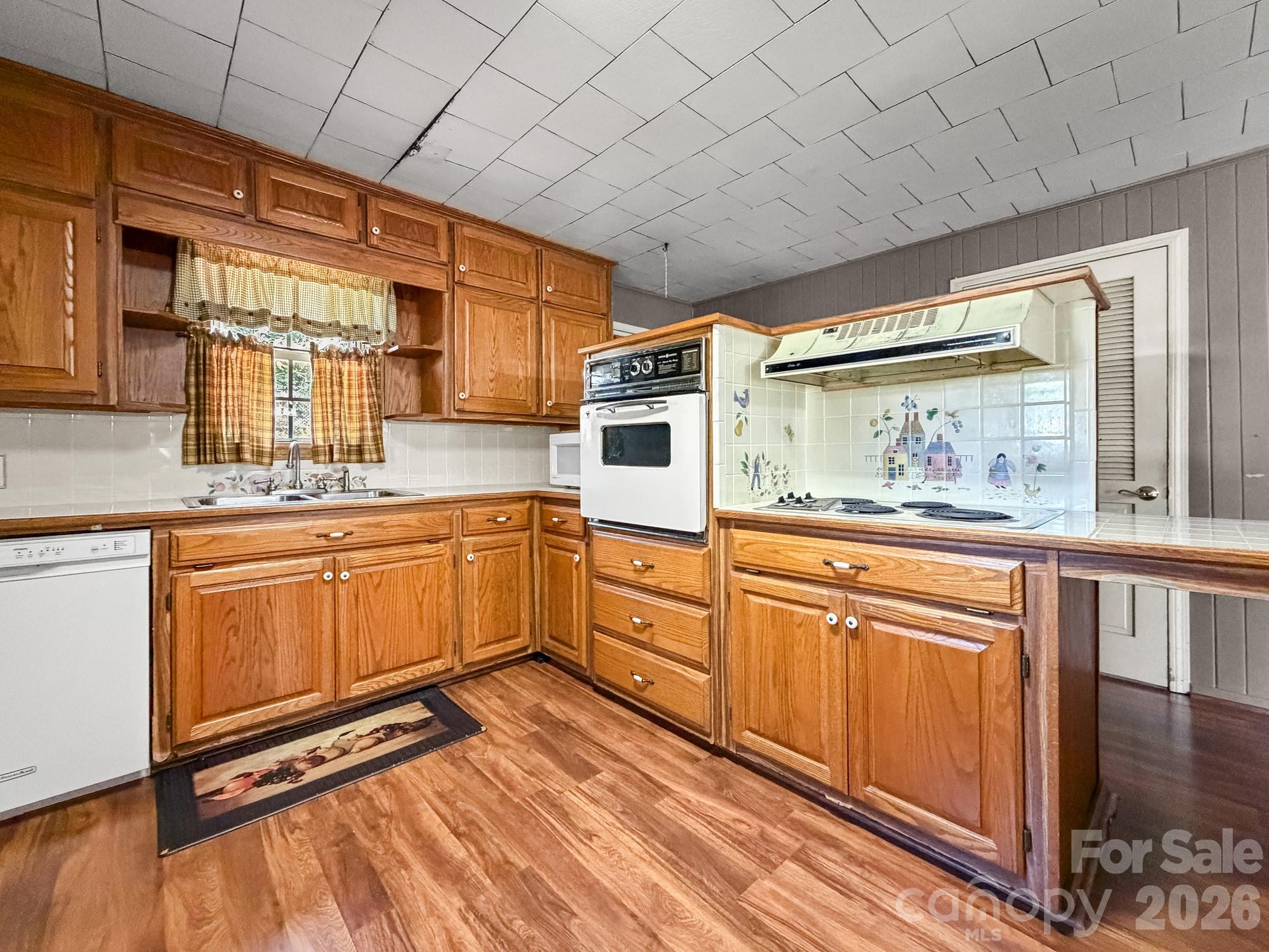 1401 East Union Street Morganton, NC 28655 - Photo 12 of 40 a kitchen with stainless steel appliances granite countertop a stove a sink and white cabinets with wooden floors