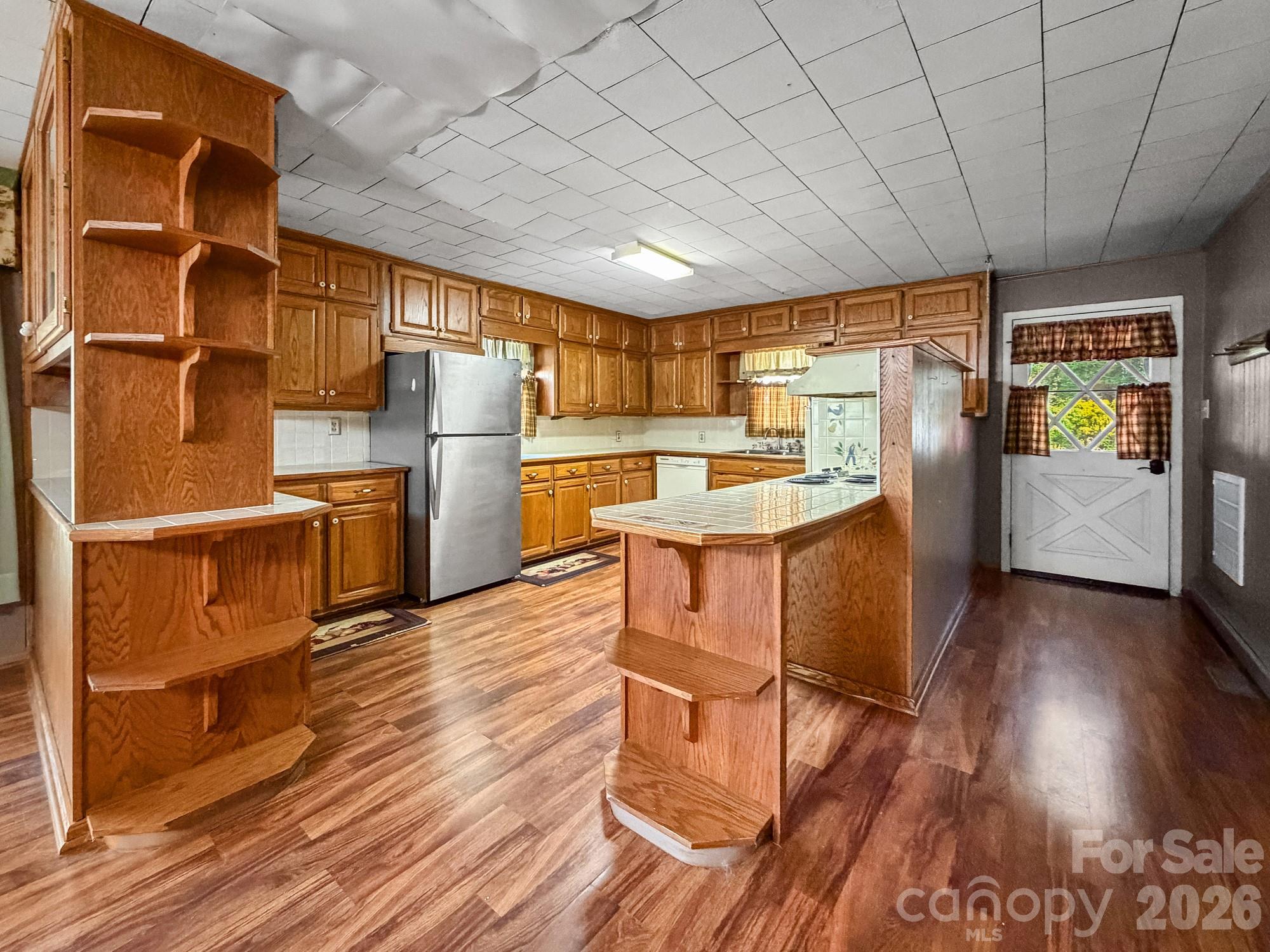 1401 East Union Street Morganton, NC 28655 - Photo 15 of 40 a kitchen with stainless steel appliances wooden floors and wooden cabinets
