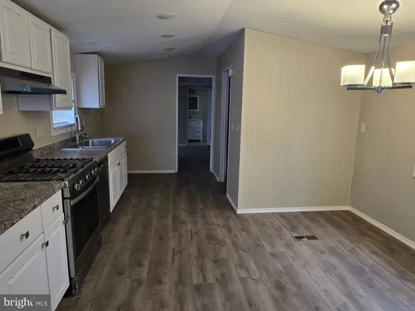 a kitchen with a wooden floor and a stove top oven