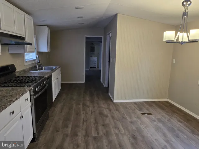 a kitchen with a wooden floor and a stove top oven
