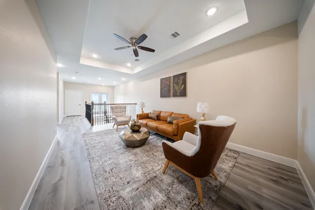 a living room with furniture and a wooden floor