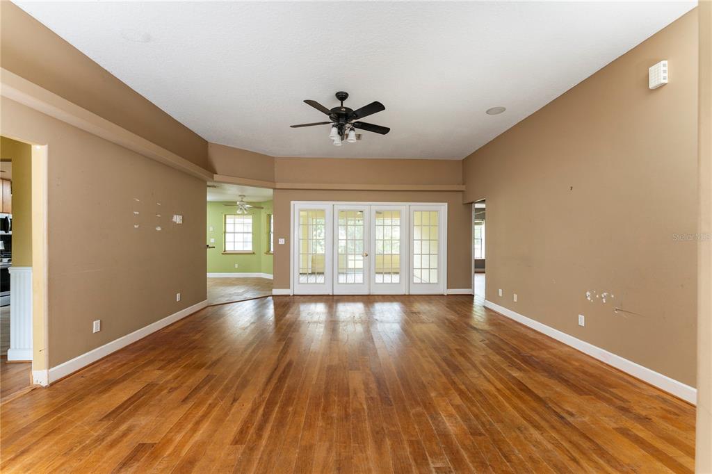 16017 Johns Lake Road Clermont, FL 34711 - Photo 29 of 62 an empty room with wooden floor and windows