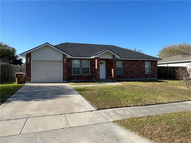 a front view of a house with a garden and yard